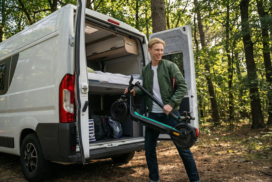 Gefalteter Egret Unit E-Scooter beim Verladen an einem Camper im Grünen